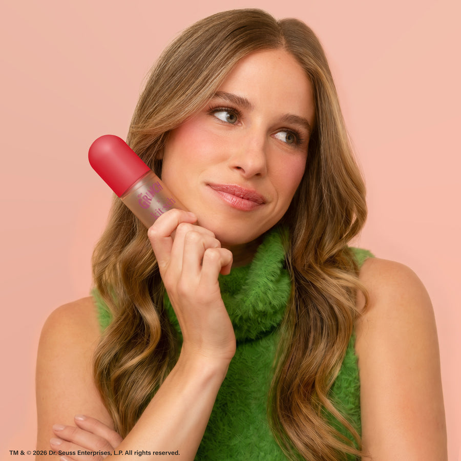 Model holding The Grinch x Kitsch Cherry Cheer Hair Perfume bottle