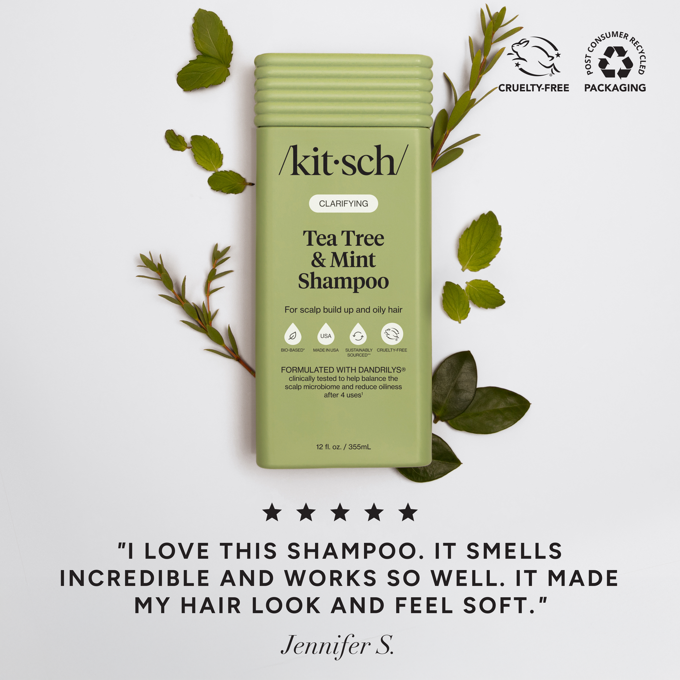 Kitsch Tea Tree & Mint Shampoo bottle with green leaves on a light gray background
