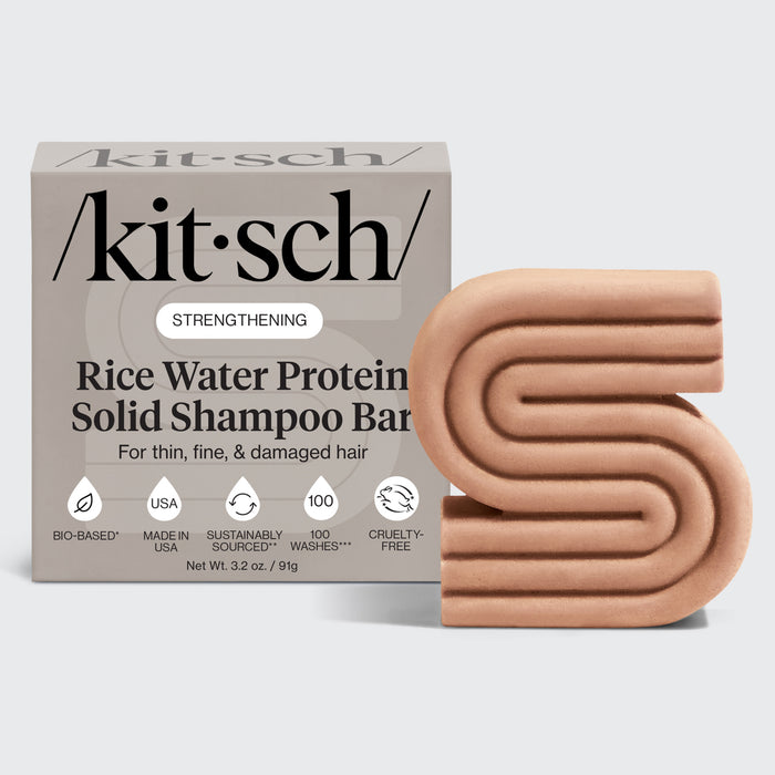 Kitsch rice water protein solid shampoo bar packaging with a beige rice water protein solid shampoo bar on a grey background