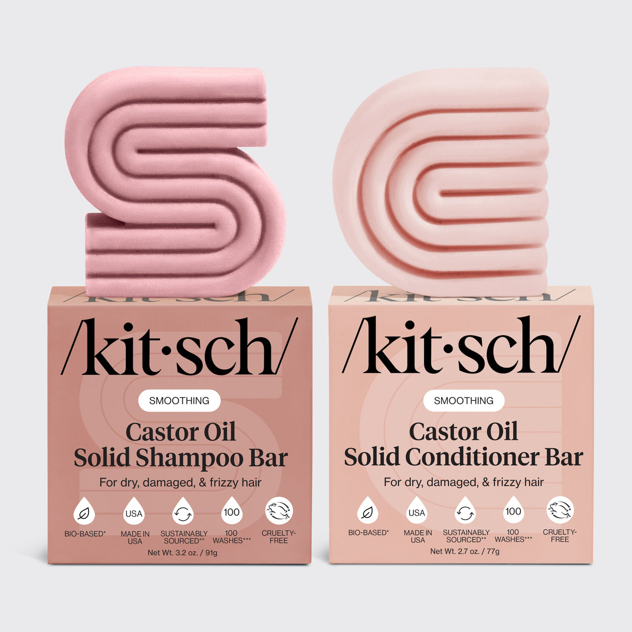 Two pink kitsch castor oil shampoo and conditioner bars with their respective boxes on a light gray background