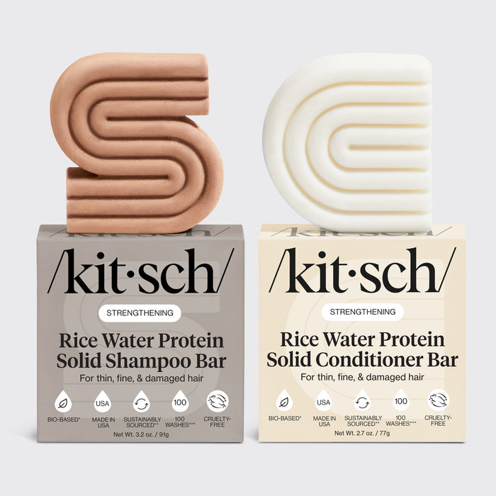 Kitsch rice water protein solid shampoo and conditioner bars on top of their packaging side by side on a light gray background.