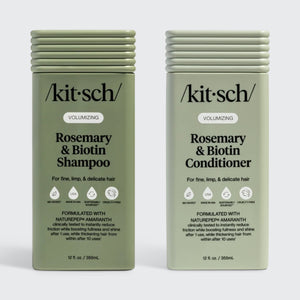 Two sage-green rectangular bottles of Kitsch Volumizing Rosemary & Biotin Shampoo and Conditioner for fine, limp, and delicate hair. The labels highlight the use of NaturePep Amaranth, noting it is clinically tested to reduce friction and boost fullness. The bottles feature icons for bio-based, made in USA, sustainably sourced, and cruelty-free.