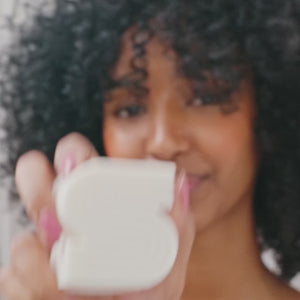 A video showing a couple of kltsch's solid shampoo and conditioner bar collection in hand